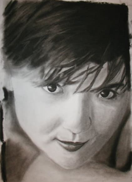 A monochrome portrait of a person with short dark hair looking directly outward.